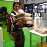 Student lifts bags of rice with University of Tokyo's bionic suit at CEATEC 2012.