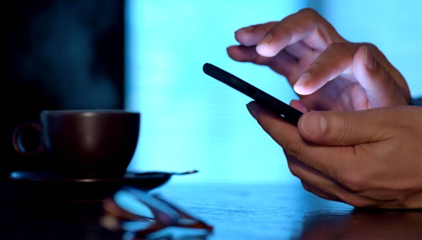 cup of coffee background man using smartphone