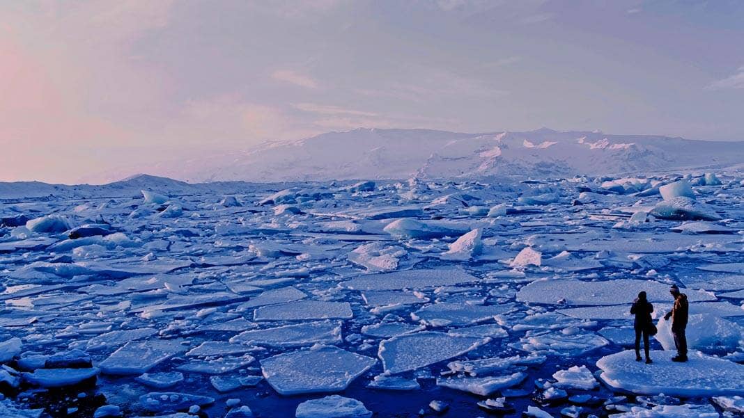 environment changing climate two people watching melting ice