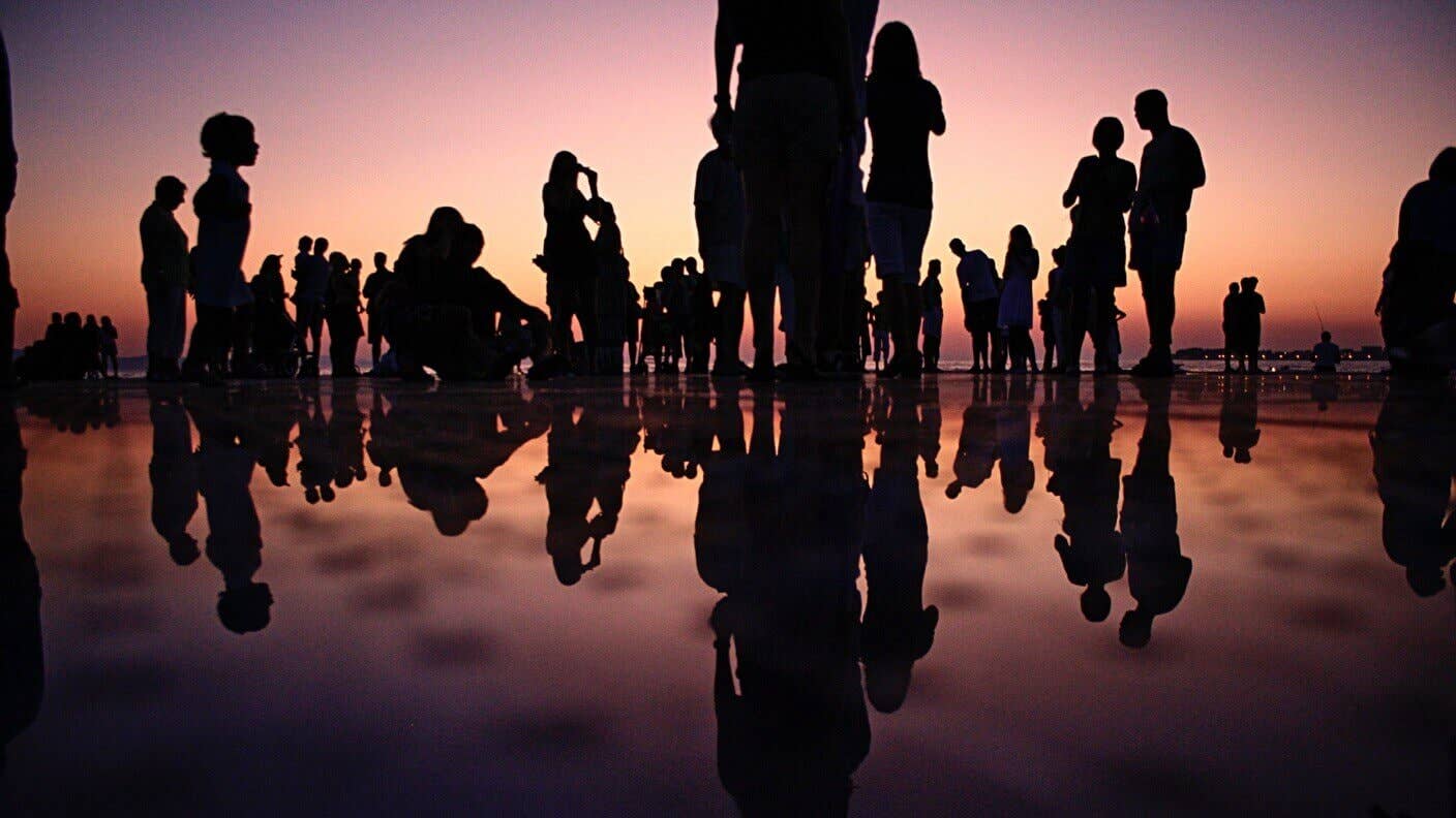 world demographics age wealth people silhouettes water beach reflection