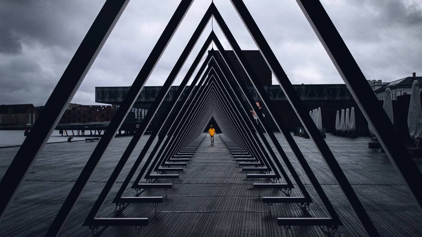 awesome tech stories triangles sculpture vanishing point person orange jacket grey sky