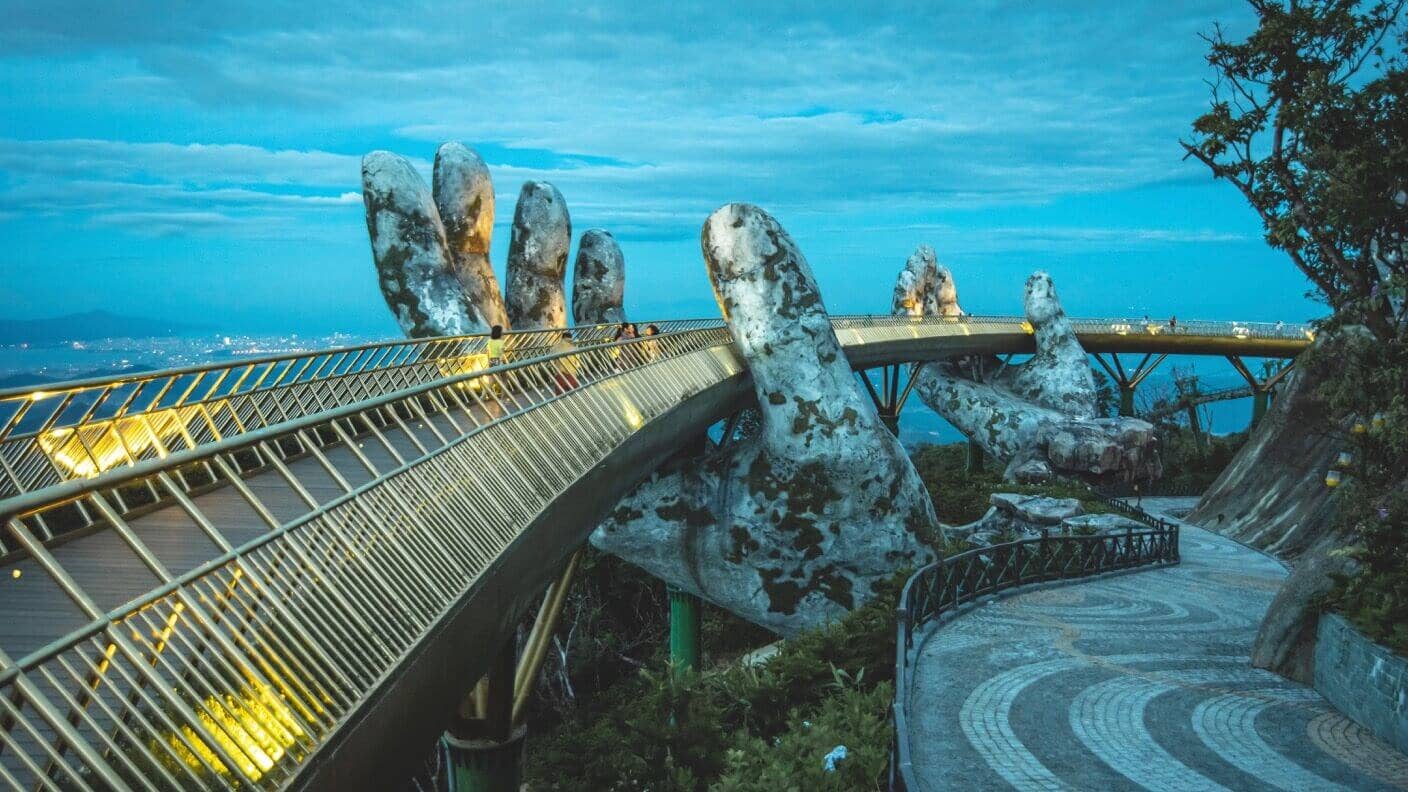 tech stories stone hands golden bridge vietnam dusk trees
