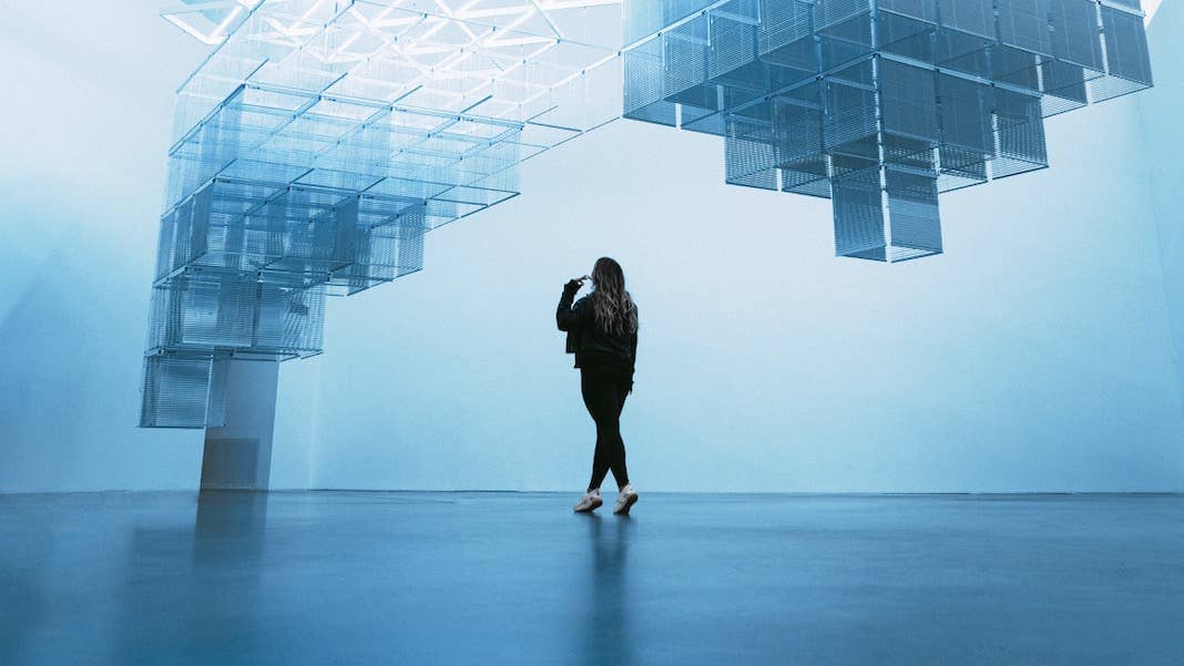 tech stories woman camera phone modern art floating blue structures