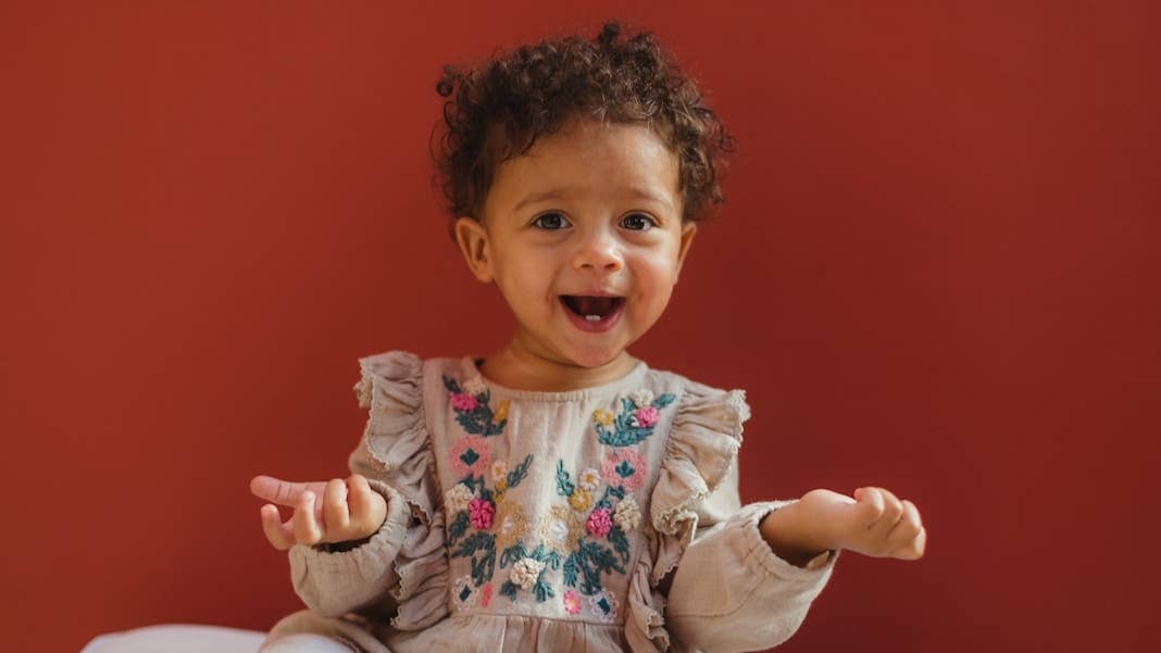 early memory infantile amnesia toddler smiling red background