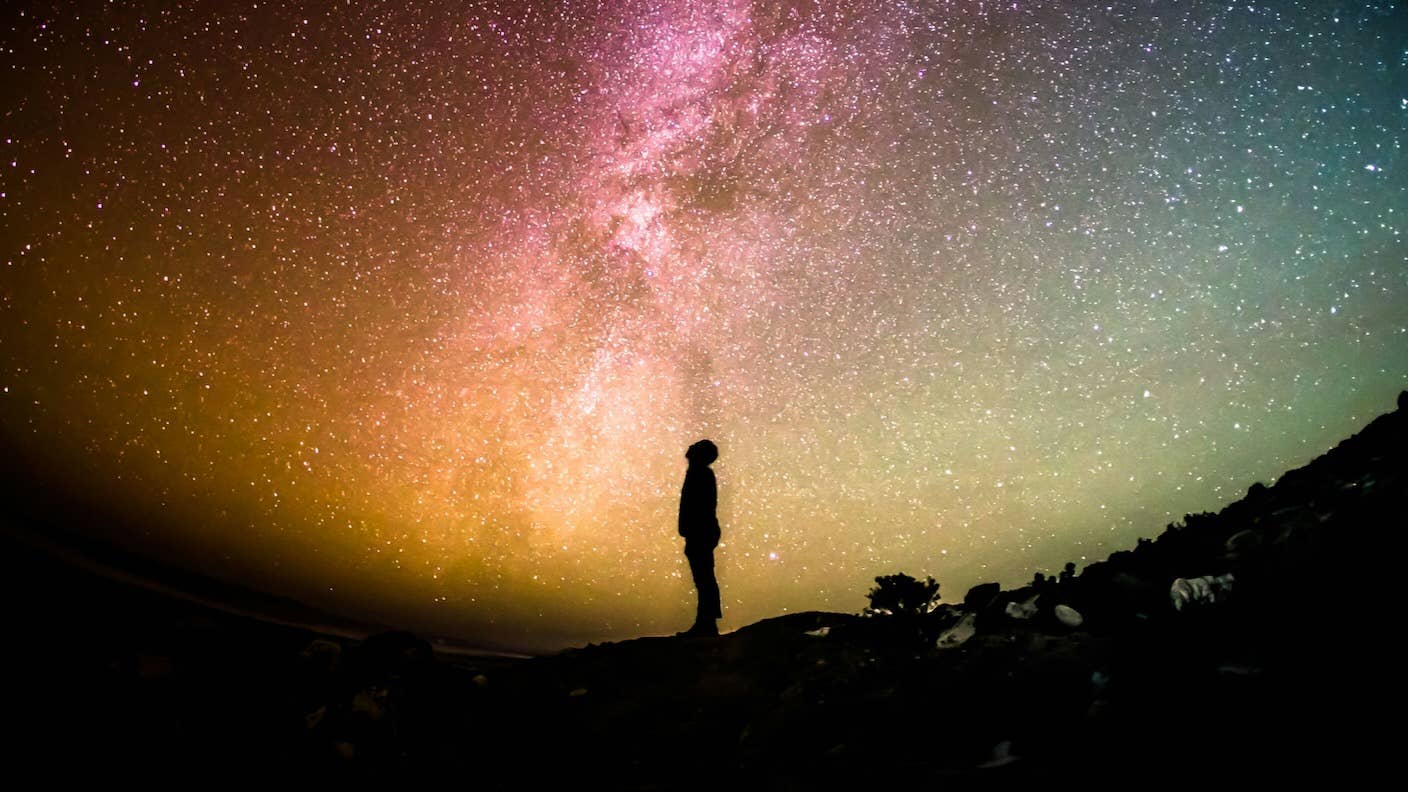 Evolving Intelligent Life May Not Have Been as Unlikely as Many Scientists Predicted A person standing under the milky way