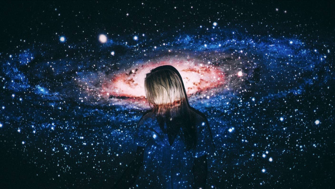 A woman standing amid a galactic swirl of stars