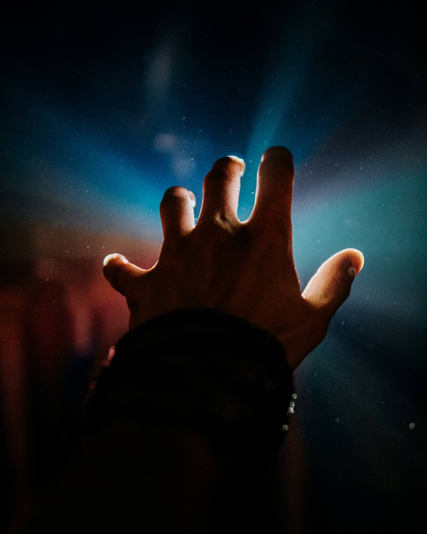 A hand reaching toward the light