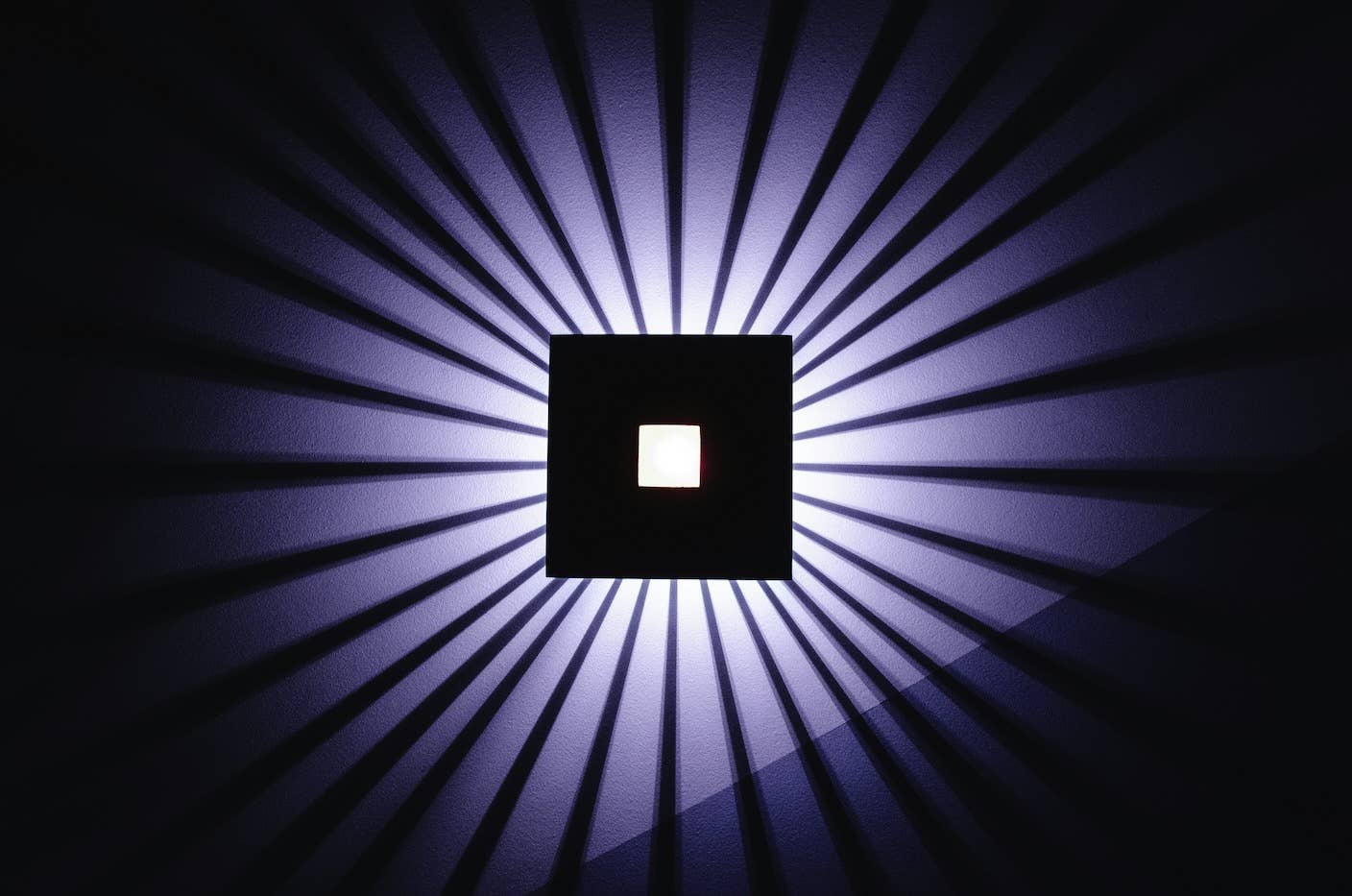 A digital design of a white square in a black square with a light source behind them.