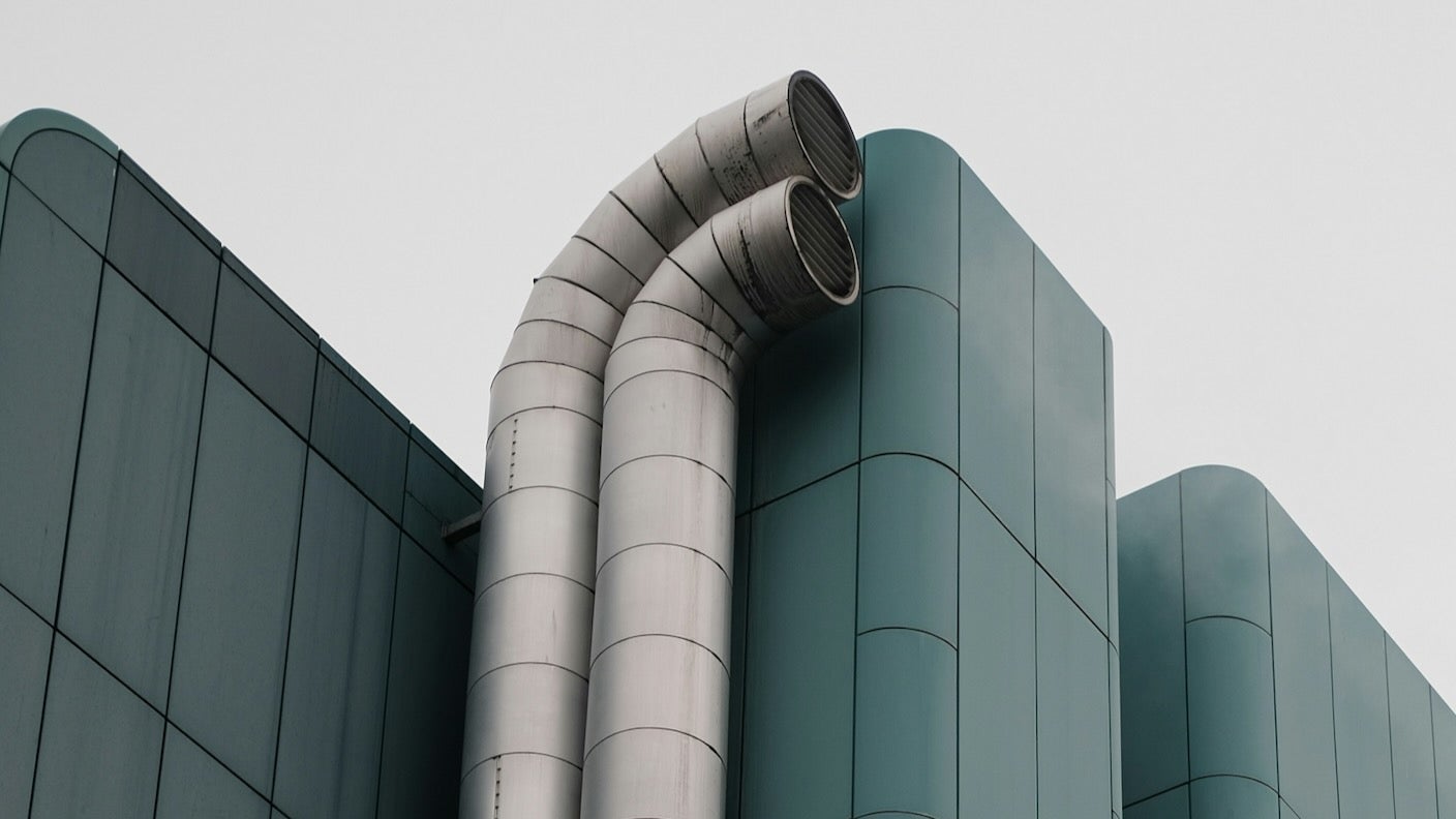 Metal vents run up the side of a green building.