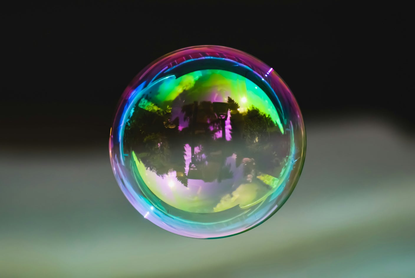 A large bubble floats in the air reflecting its surroundings