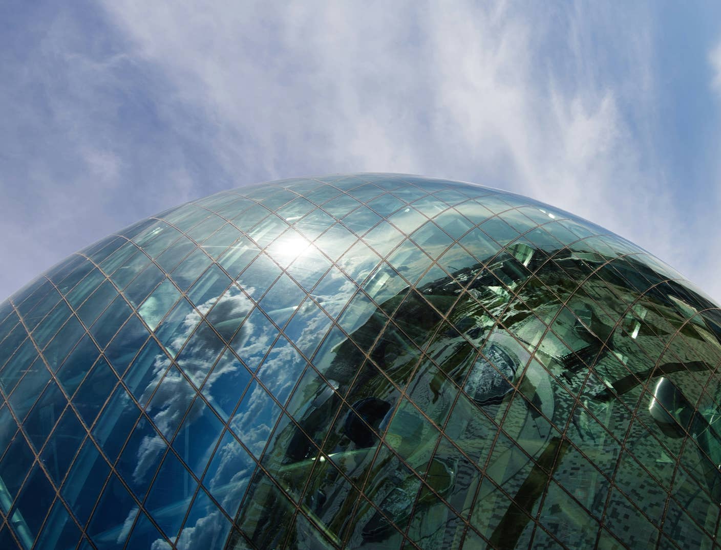 AI Companies Are Betting Billions on AI Scaling Laws. Will Their Wager Pay Off? A sphere-like glass building curves and reflects clouds and sky