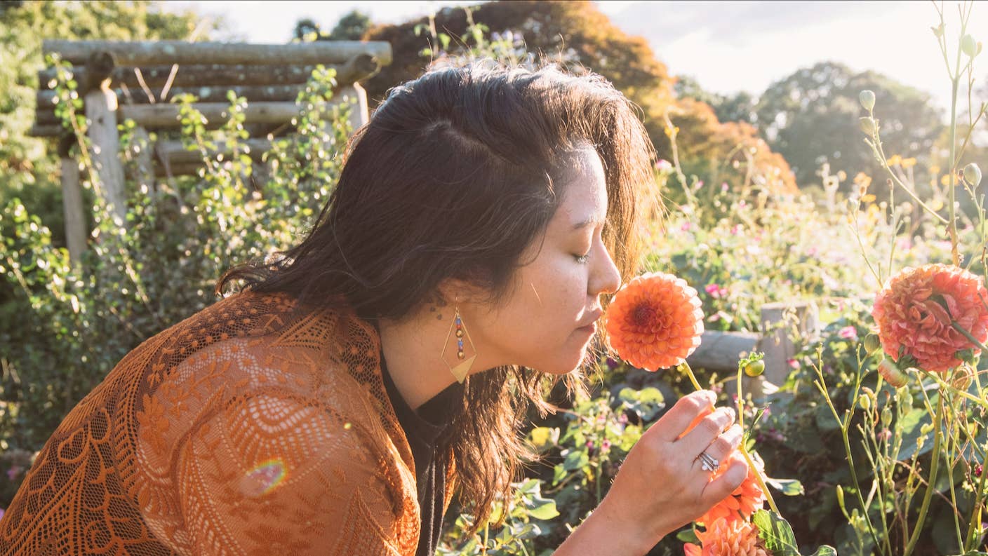 Humans Could Have as Many as 33 Senses A woman stoops to smell a flower in the garden
