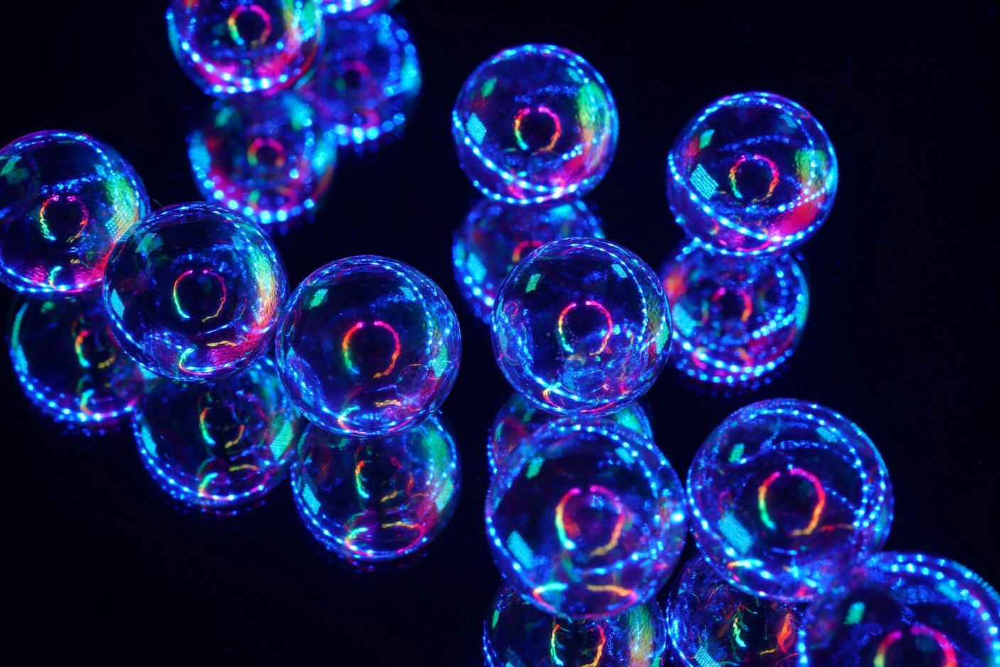 Blue and clear glass balls with reflected lights on black background