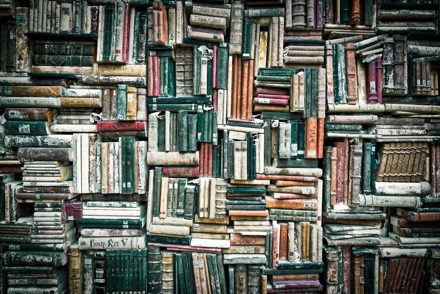 A dense stack of old, tattered books
