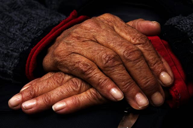 Your Genes Determine How Long You’ll Live Far More Than Previously Thought Hands resting on one another in blue sweater with red cuffs