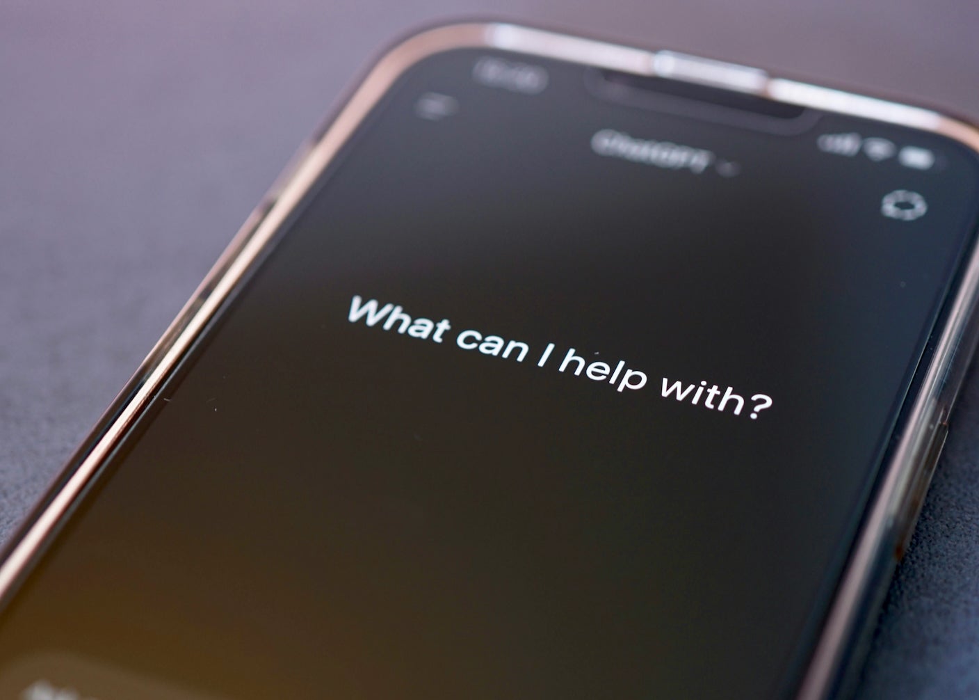 A smartphone with the message "What can I help you with" on its display