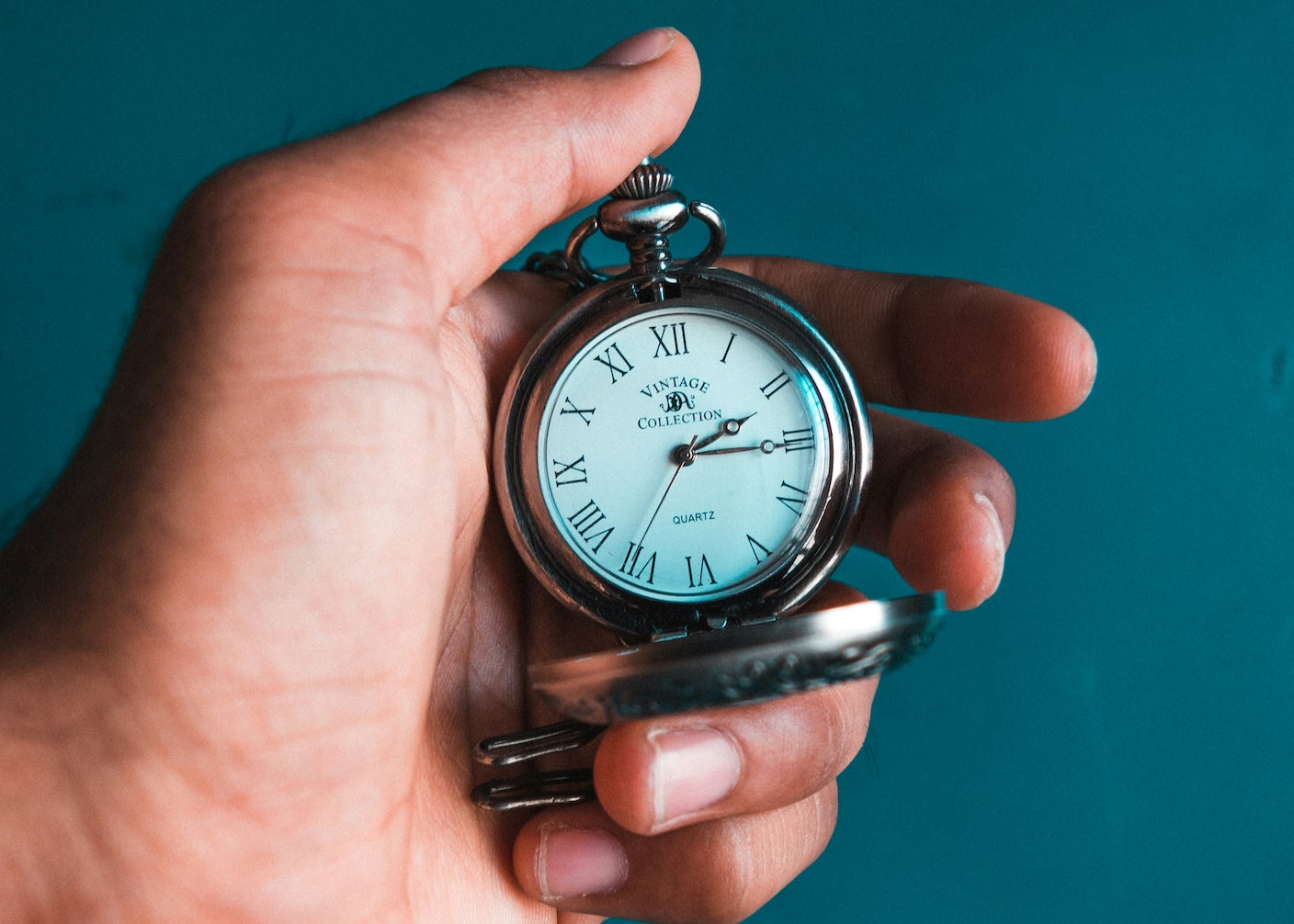 A hand holding an analog watch