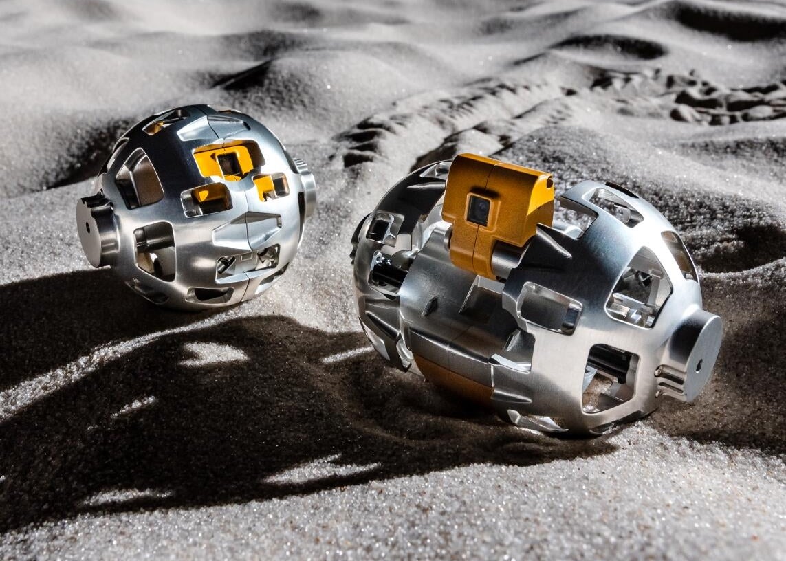 A pair of JAXA moon robots, one closed up and one open and ready to navigate