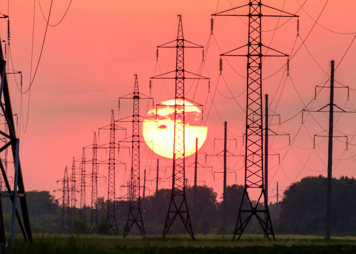 Solar Beat Coal in US Electricity Mix for the First Time in May The sun and a red sky behind power lines marching into the distance