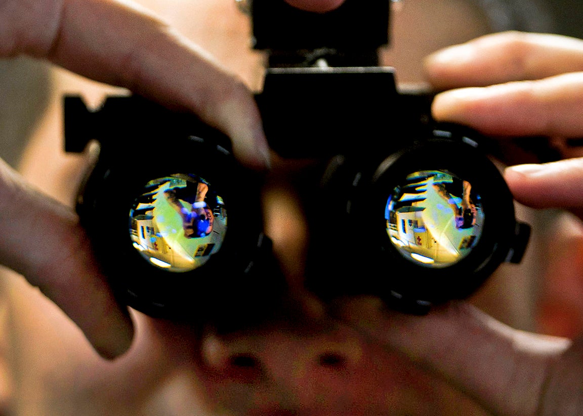 Person adjusts night vision goggles