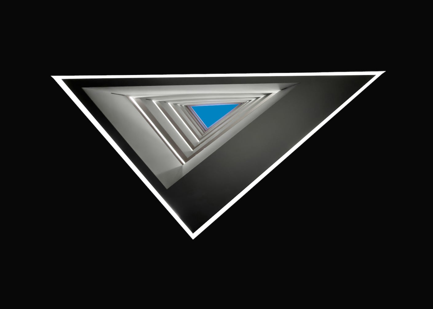 A cropped triangle of architectural design with blue sky in the middle