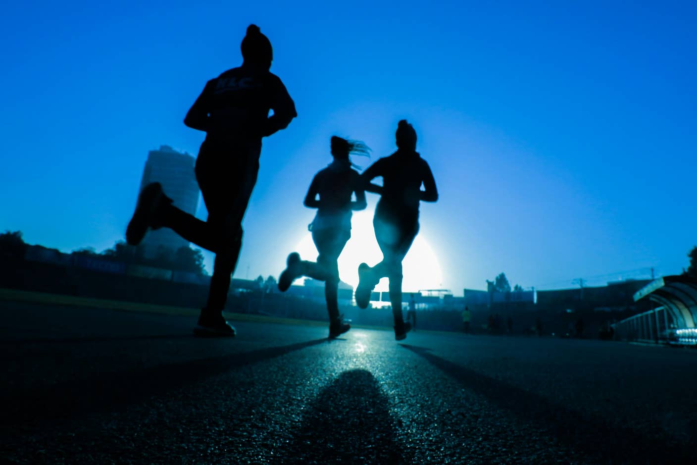 Could GLP-1 Drugs Help You Live a Longer, Healthier Life? Three runners jogging silhouetted against the sun and blue sky.