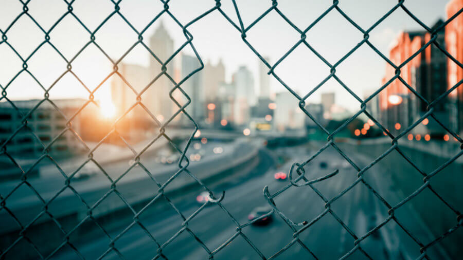 city-sunrise-skyline-through-wire-mesh