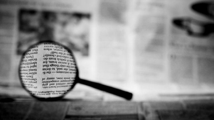 magnifying glass newspaper artificial intelligence