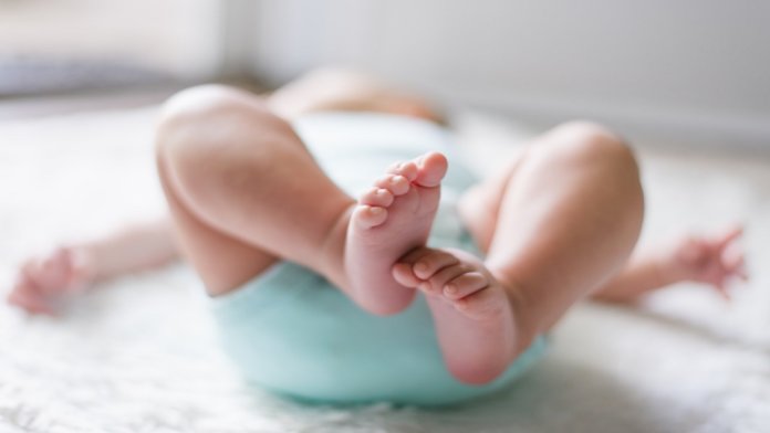 baby lying on bed designer babies CRISPR